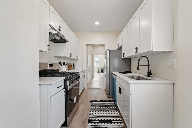 kitchen featuring stainless steel appliances, light wood-type flooring, and white cabinetry