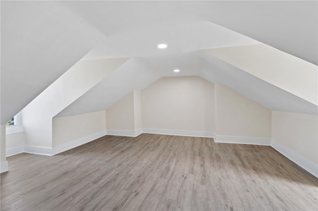 bonus room featuring lofted ceiling and light hardwood / wood-style floors