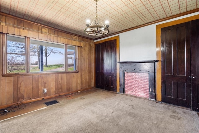 interior space featuring carpet, an inviting chandelier, and crown molding