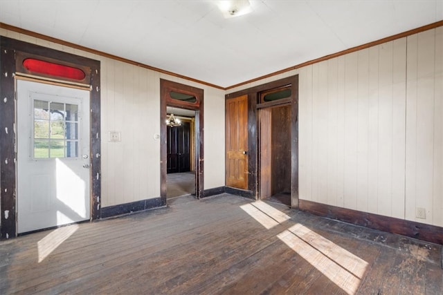 spare room featuring dark hardwood / wood-style floors and crown molding