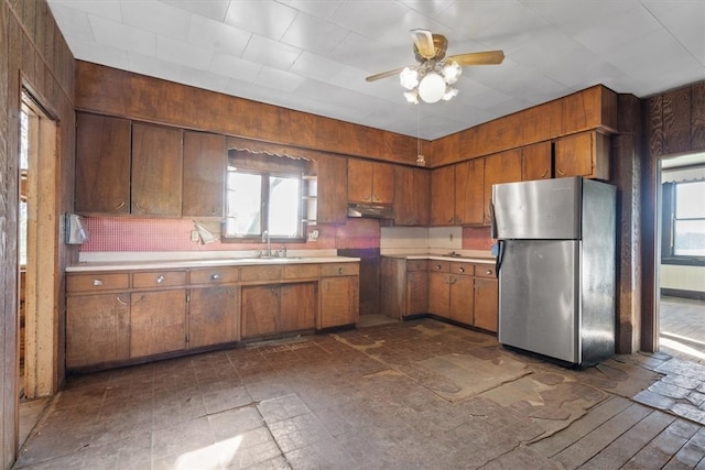 kitchen featuring sink, ceiling fan, stainless steel fridge, and dark tile flooring