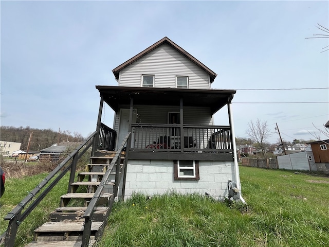 back of house with a porch and a yard