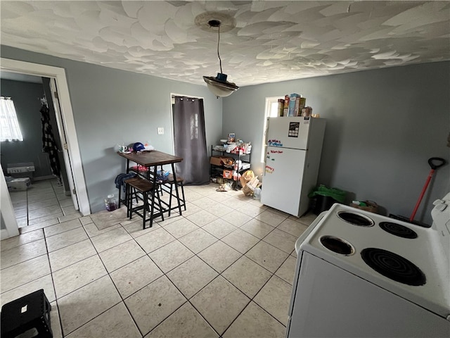 kitchen featuring white appliances, light tile flooring, and decorative light fixtures