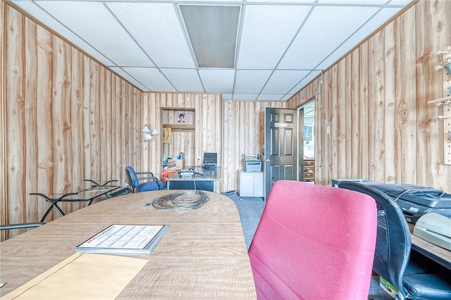 interior space with wooden walls and a drop ceiling