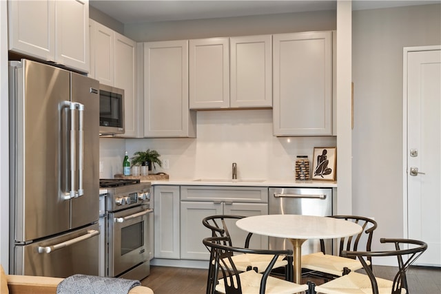 kitchen with dark hardwood / wood-style floors, sink, and high quality appliances