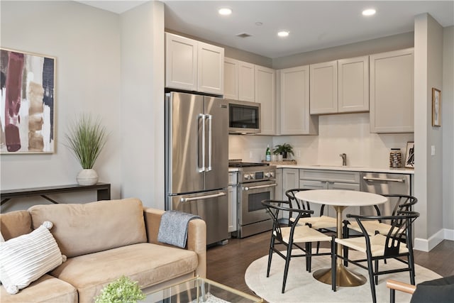 kitchen featuring gray cabinets, sink, dark hardwood / wood-style flooring, and premium appliances