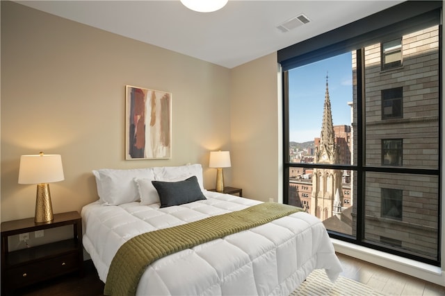 bedroom featuring expansive windows and light wood-type flooring