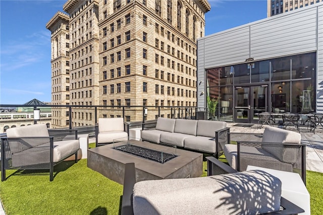 view of terrace with an outdoor living space with a fire pit