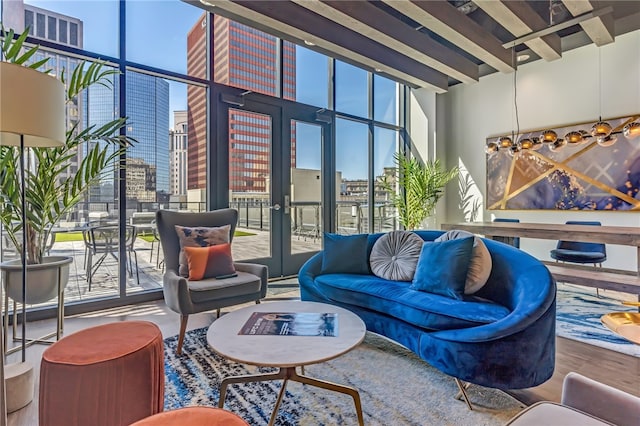 living room featuring french doors, a towering ceiling, wood-type flooring, and expansive windows