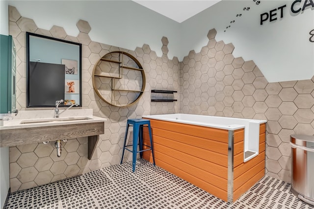 bathroom featuring sink and tile walls