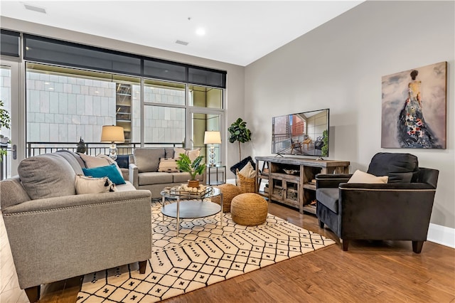 living room with light hardwood / wood-style flooring, expansive windows, and a wealth of natural light