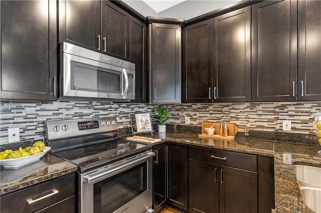 kitchen with appliances with stainless steel finishes, dark stone countertops, and tasteful backsplash