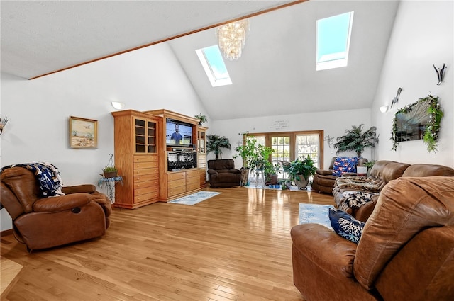 living room with light hardwood / wood-style floors, high vaulted ceiling, a chandelier, and a skylight