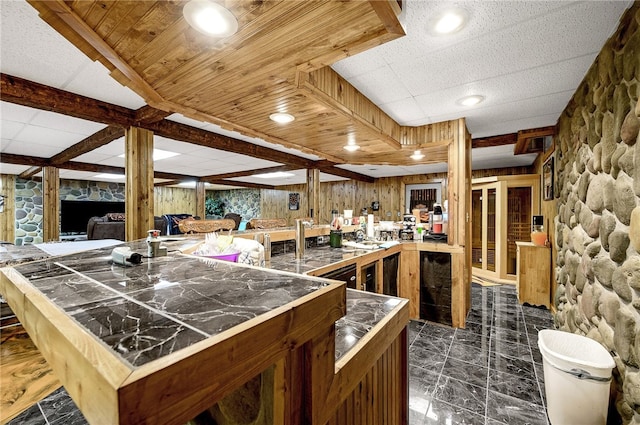 kitchen featuring wooden walls and dark tile flooring