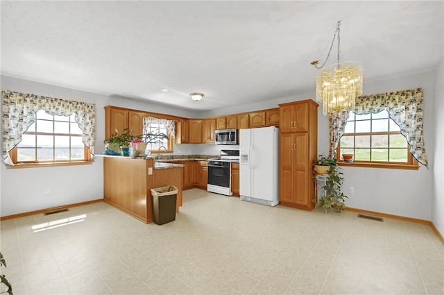 kitchen with white appliances, light tile flooring, a healthy amount of sunlight, and kitchen peninsula