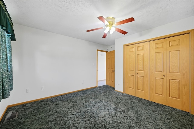 unfurnished bedroom with a textured ceiling, a closet, ceiling fan, and carpet floors