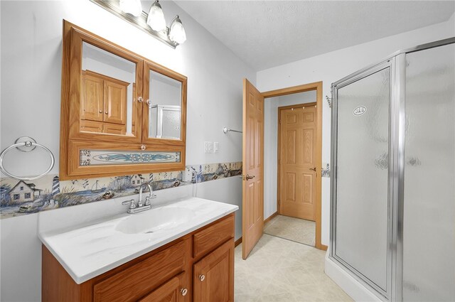 bathroom with tile flooring, an enclosed shower, vanity, and a textured ceiling