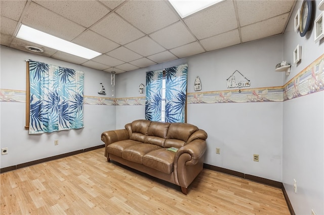 interior space with a drop ceiling and light hardwood / wood-style flooring