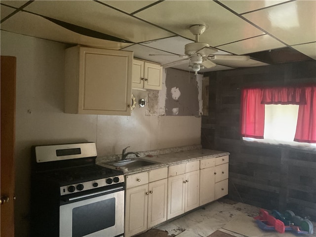 kitchen featuring stainless steel range with electric stovetop, ceiling fan, sink, and light tile flooring