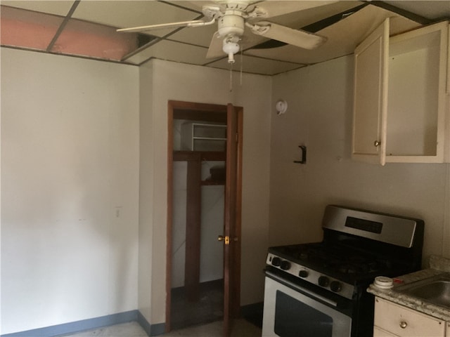 kitchen with ceiling fan, electric stove, a paneled ceiling, and white cabinetry