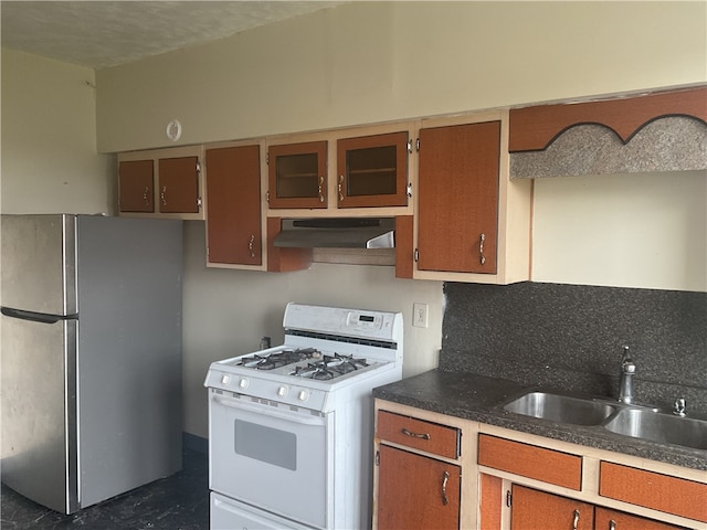 kitchen featuring sink, tasteful backsplash, white gas range, stainless steel fridge, and extractor fan