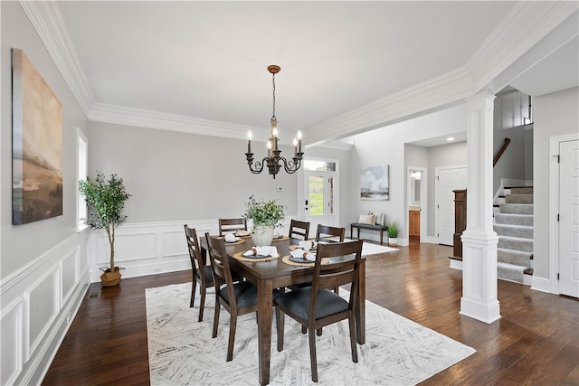 dining room with decorative columns, dark wood-type flooring, a chandelier, and ornamental molding