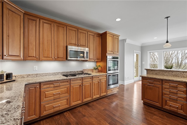 kitchen featuring decorative light fixtures, appliances with stainless steel finishes, crown molding, light stone counters, and dark hardwood / wood-style flooring