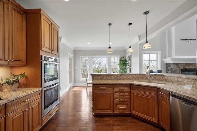 kitchen with stainless steel appliances, pendant lighting, dark wood-type flooring, and light stone countertops