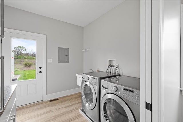 clothes washing area featuring light hardwood / wood-style flooring, washer and dryer, and washer hookup