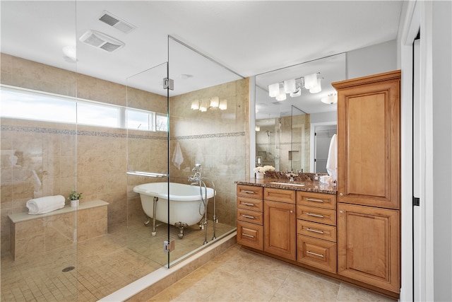 bathroom featuring vanity with extensive cabinet space, independent shower and bath, tile flooring, and tile walls