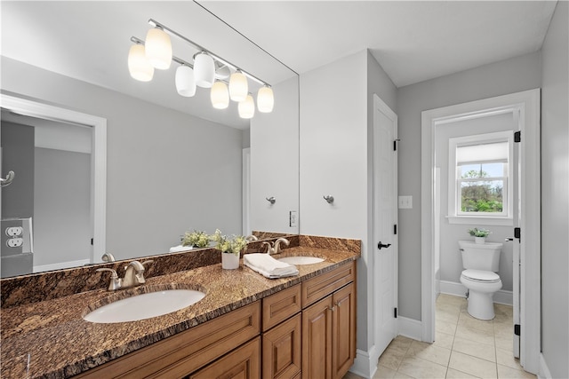 bathroom featuring tile floors, toilet, and dual bowl vanity