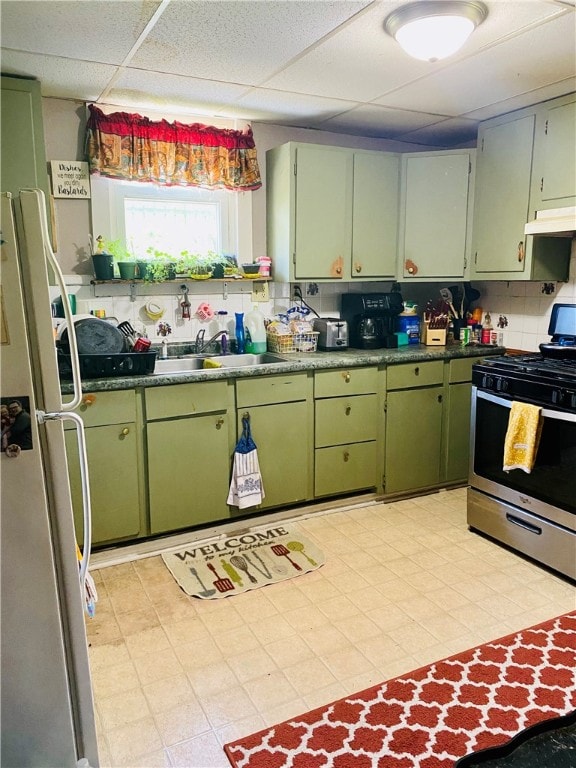 kitchen with a drop ceiling, tasteful backsplash, stainless steel appliances, and light tile floors