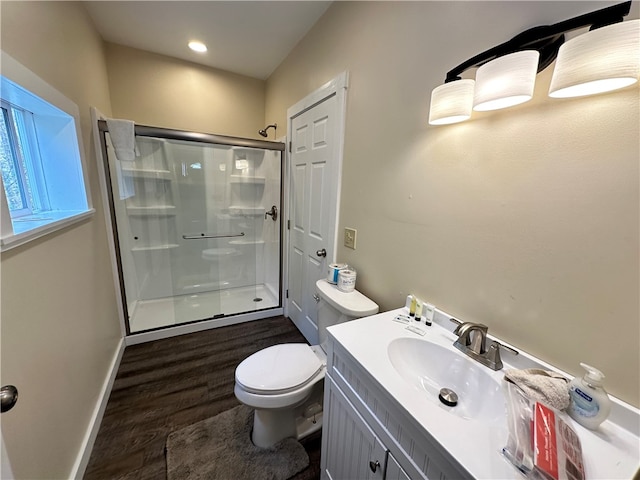 bathroom with wood-type flooring, a shower with shower door, vanity, and toilet