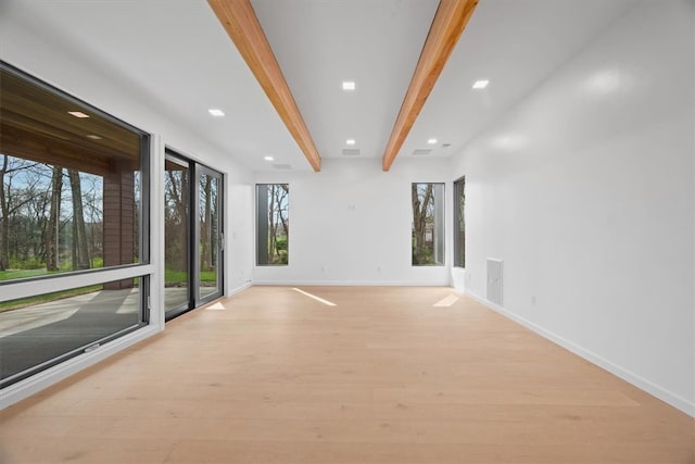 spare room with beam ceiling and light hardwood / wood-style floors