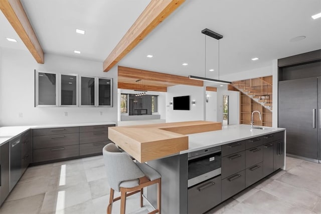 kitchen with high quality fridge, beamed ceiling, decorative light fixtures, and light tile patterned floors