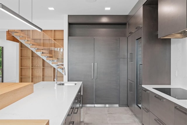 kitchen featuring sink, light tile patterned flooring, and black electric cooktop