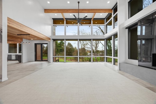 interior space featuring a high ceiling, beamed ceiling, and a wealth of natural light