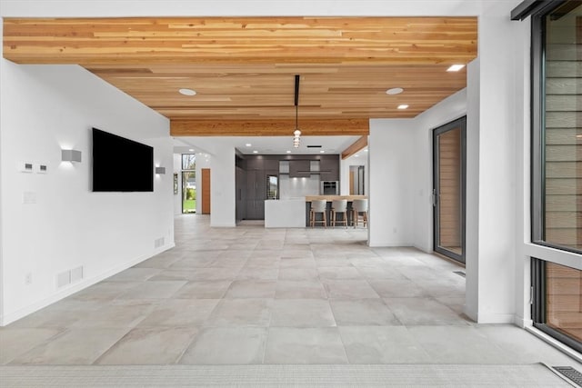 unfurnished living room with tile patterned floors and wood ceiling