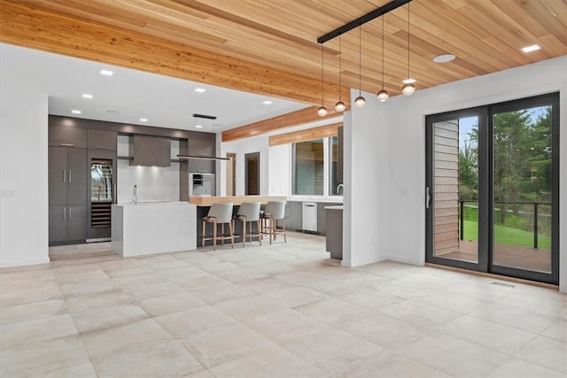 kitchen featuring a kitchen bar, dark brown cabinets, light tile patterned floors, oven, and a center island