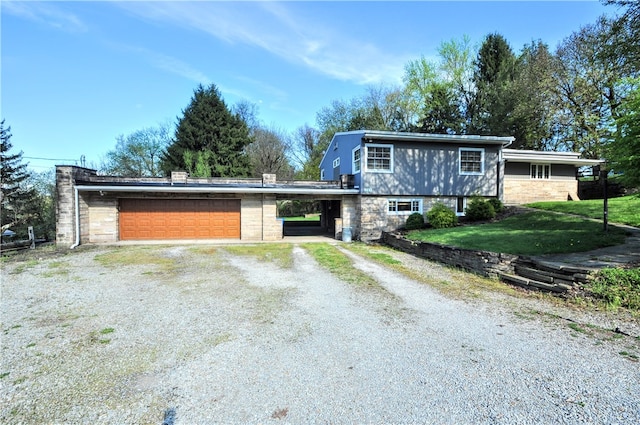 view of front of property with a front lawn, a carport, and a garage