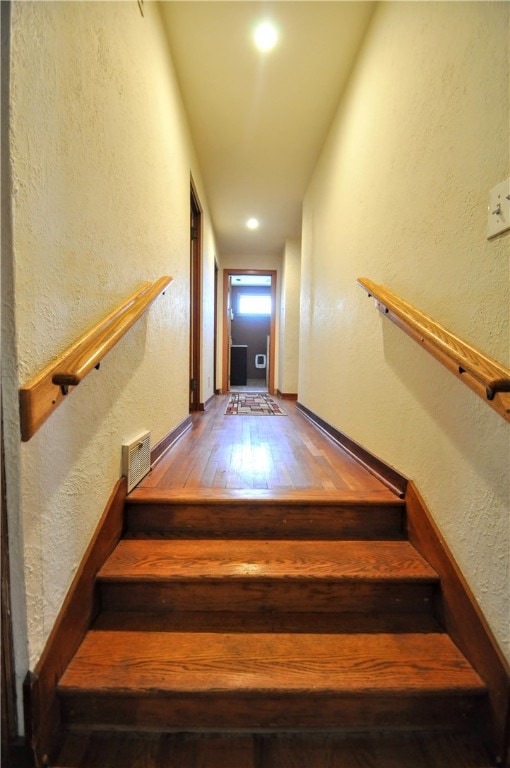 stairway with dark hardwood / wood-style flooring