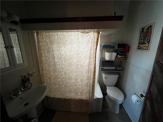 bathroom featuring sink, tile walls, and toilet