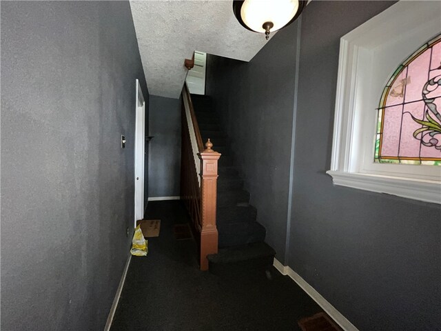 stairs featuring a textured ceiling