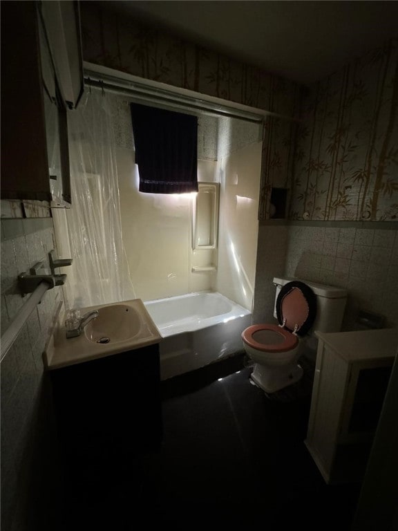 full bathroom featuring washtub / shower combination, tile walls, vanity, and toilet