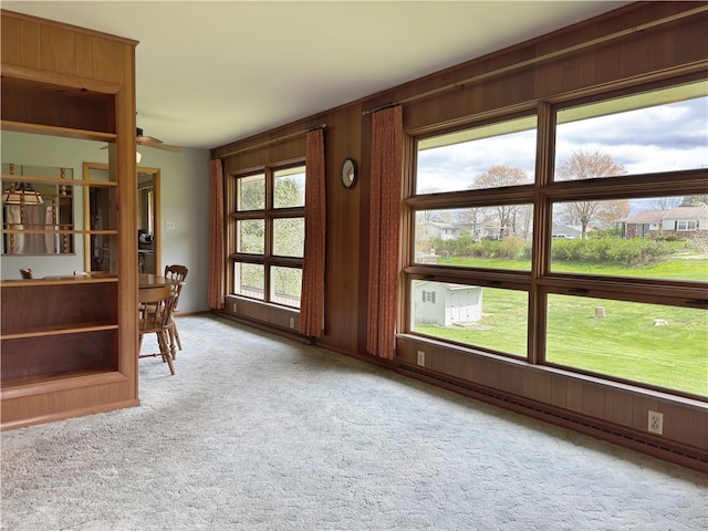 empty room featuring wood walls and light colored carpet