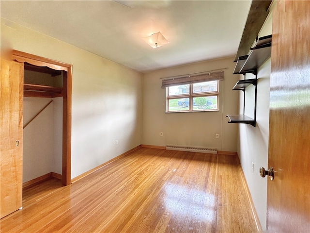 interior space with baseboard heating, light hardwood / wood-style flooring, and a closet