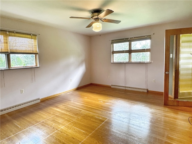 unfurnished room featuring a healthy amount of sunlight, baseboard heating, ceiling fan, and light hardwood / wood-style floors