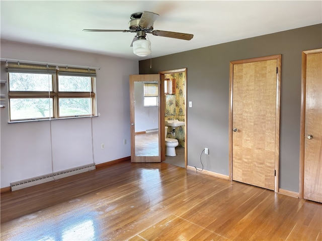 unfurnished bedroom featuring ceiling fan, light wood-type flooring, baseboard heating, and multiple windows