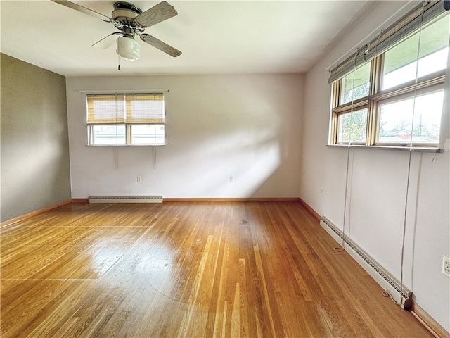 spare room with light hardwood / wood-style flooring, ceiling fan, and a baseboard heating unit