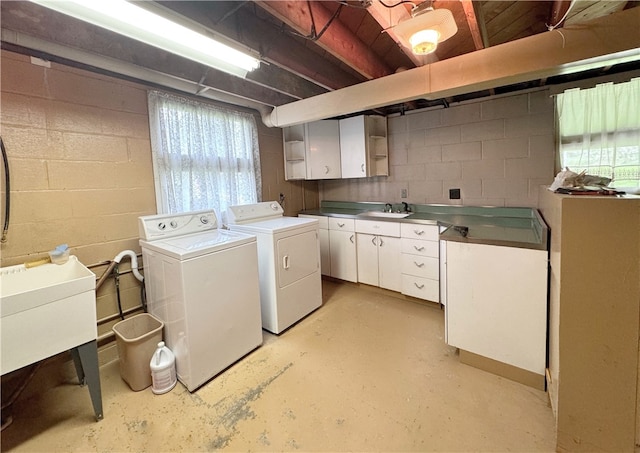 washroom featuring cabinets, sink, and washer and dryer